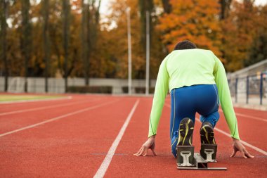 Sportif delikanlı koşu parkurundakilerden çalışmaya hazır. Büyük güzel modern Stadı nda düzgün biçimli insanların uygun