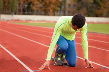 Sportif delikanlı koşu parkurundakilerden çalışmaya hazır. Büyük güzel modern Stadı nda düzgün biçimli insanların uygun