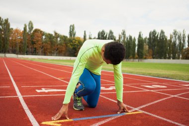 Sportif delikanlı koşu parkurundakilerden çalışmaya hazır. Büyük güzel modern Stadı nda düzgün biçimli insanların uygun