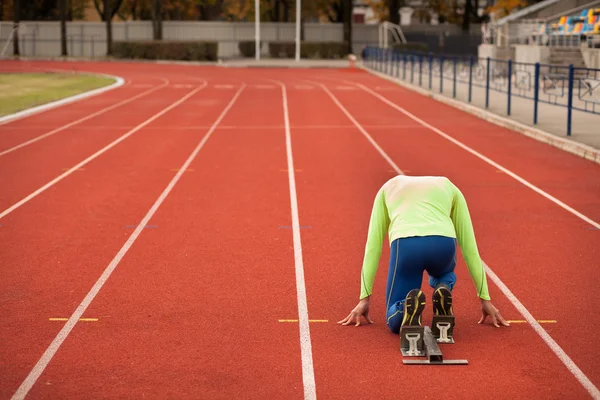 Sportif delikanlı koşu parkurundakilerden çalışmaya hazır. Büyük güzel modern Stadı nda düzgün biçimli insanların uygun