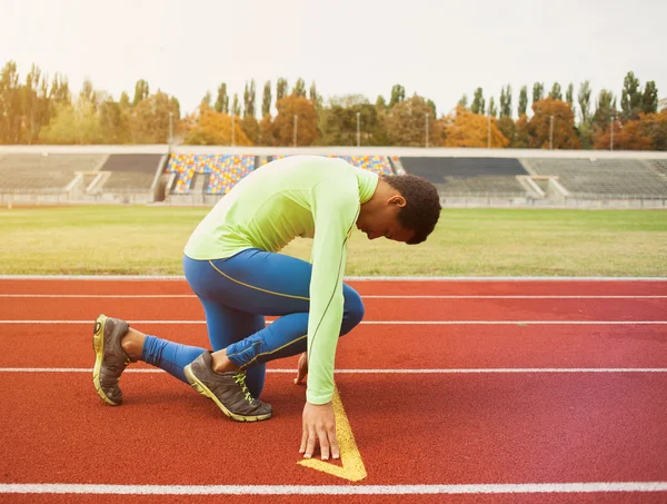 Junge sportliche Mann sind bereit, auf der Rennstrecke zu laufen. fit gut ausgebildete Menschen in großen schönen modernen Stadion — Stockfoto