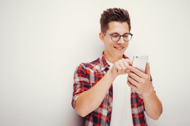 Gençlik ve teknoloji. Stüdyo akıllı telefon kullanan adam portresi. İzole