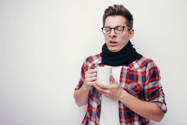 Mann mit Grippe und Fieber eingewickelt hält Tasse Heiltee isoliert über weißem. — Stockfoto