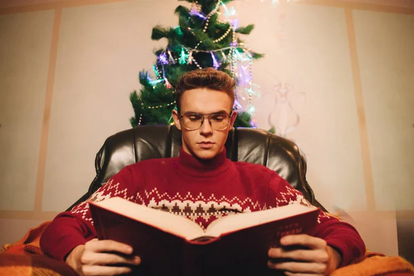 Lectura chico en el fondo de árbol de Navidad y chimenea — Foto de Stock