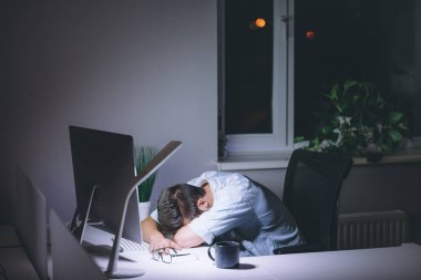Bilgisayarda çalışma gece karanlık ofisinde uyuyan genç adam