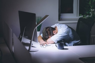 Bilgisayarda çalışma gece karanlık ofisinde uyuyan genç adam