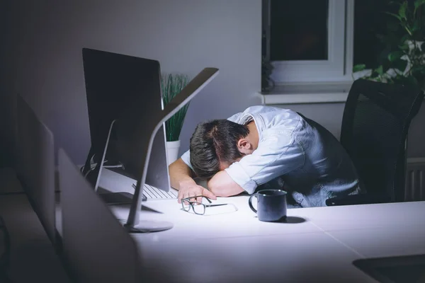 Dormir joven trabajando en la computadora por la noche en la oficina oscura — Foto de Stock