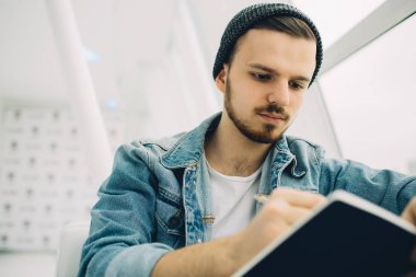 Adam kanepede oturan ve not yazma