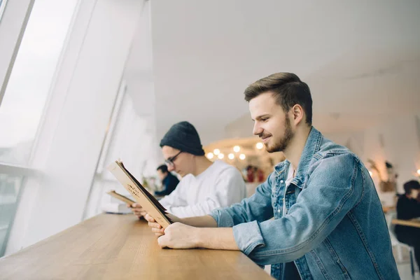 Männer sitzen vor dem Tisch am Fenster — Stockfoto