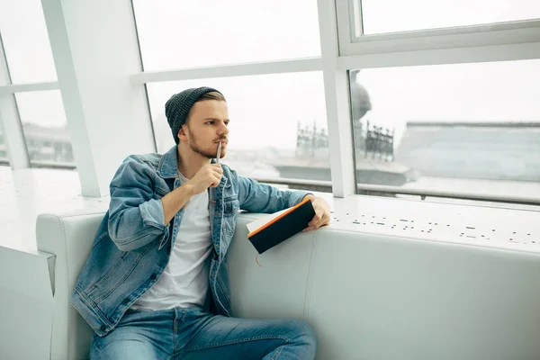 Guy is zittend op een bank en schrijven van notities — Stockfoto