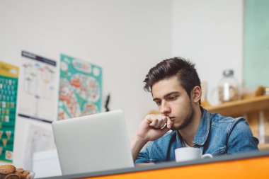 Dizüstü bilgisayarda çalışma sakallı genç ciddi adam