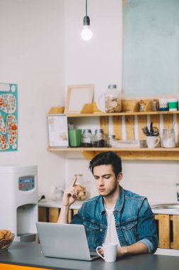 dizüstü bilgisayarda çalışan sakallı genç adam