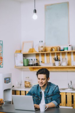 dizüstü bilgisayarda çalışan sakallı genç adam