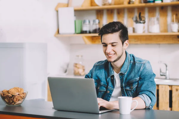 dizüstü bilgisayarda çalışan sakallı genç adam