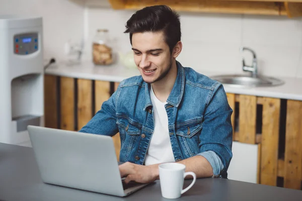 Jonge man met baard die op laptop werkt — Stockfoto