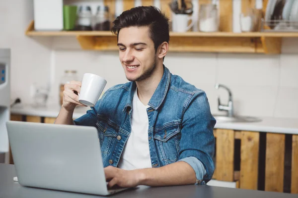 Jonge man met baard die op laptop werkt — Stockfoto