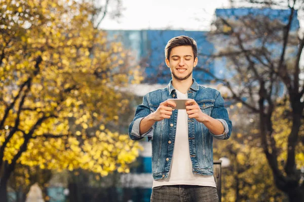 Jonge man die buiten houden van mobiele telefoon — Stockfoto