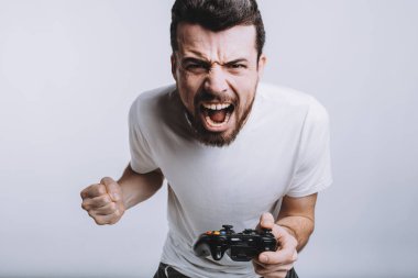 Joystick oyunlar oynuyor gibi davranarak tutan sakallı genç adam