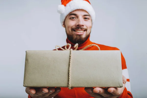 Przystojny mężczyzna oferujący prezent na Boże Narodzenie. Na białym tle — Zdjęcie stockowe