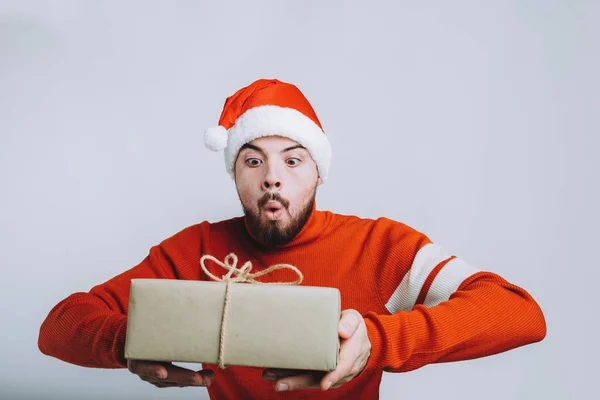 Un hombre guapo sosteniendo un regalo de Navidad. Aislado sobre fondo blanco — Foto de Stock