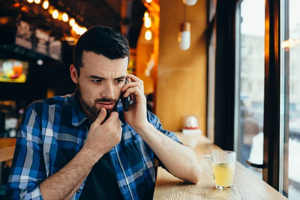 A fiatalember beszél a telefonon a café — Stock Fotó