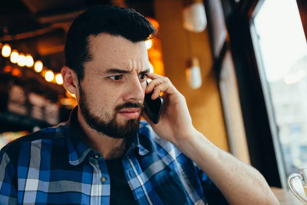 A fiatalember beszél a telefonon a café — Stock Fotó