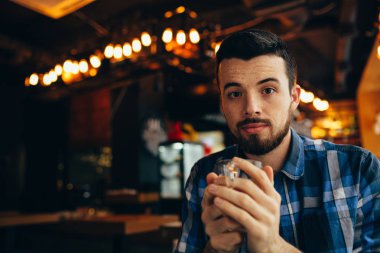 Kameraya bakarak ve çay tutarak doğal yakışıklı