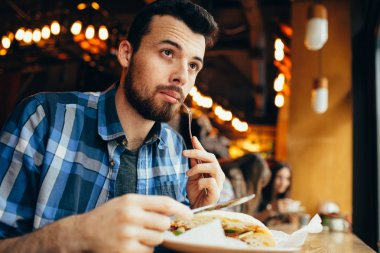 Zarif restoranda öğle yemeği yakışıklı genç