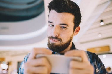 Kentsel arka plan üzerinde cep telefonunu alarak resim genç adam