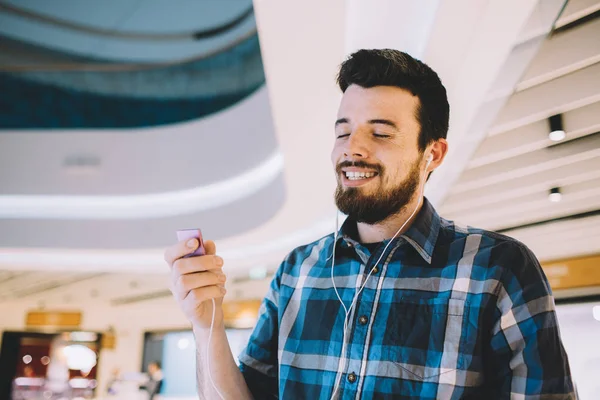 Porträt eines jungen gutaussehenden Mannes mit mp3 und Kopfhörern im urbanen Hintergrund — Stockfoto