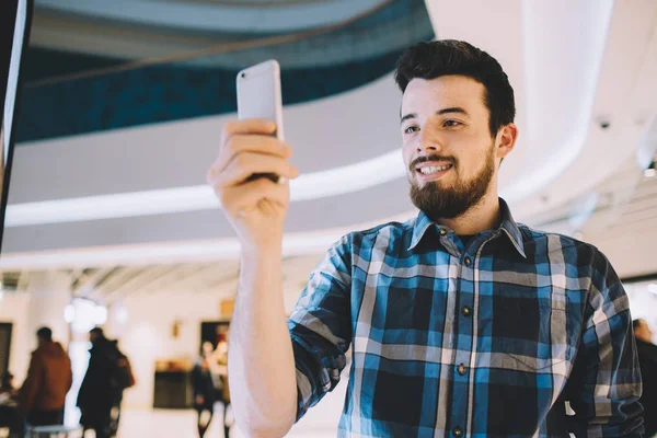 Genç adam bir şey cep telefonundan kentsel arka plan üzerinde filme