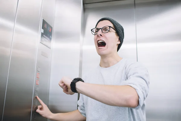 Κομψό νεαρός στέκεται σε ασανσέρ — Φωτογραφία Αρχείου