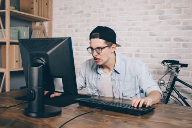 Genç adam evde oyun oynuyor ve video oynatıyor.