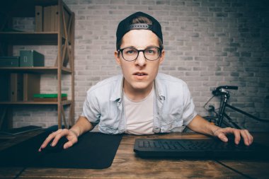 Genç adam evde oyun oynuyor ve video oynatıyor.