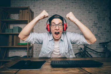 Genç adam evde oyun oynuyor ve video oynatıyor.