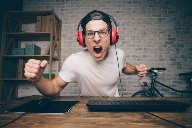 Genç adam evde oyun oynuyor ve video oynatıyor.