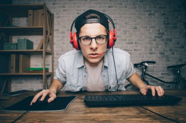 Genç adam evde oyun oynuyor ve video oynatıyor.