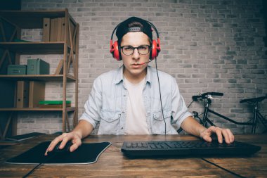 Genç adam evde oyun oynuyor ve video oynatıyor.