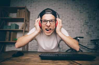 Genç adam evde oyun oynuyor ve video oynatıyor.