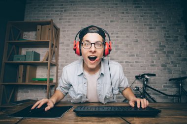 Genç adam evde oyun oynuyor ve video oynatıyor.