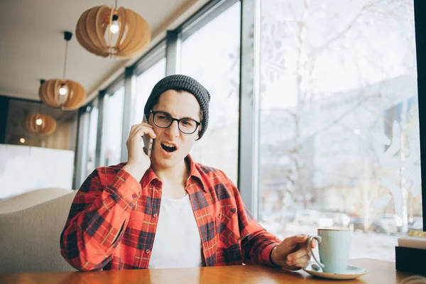 Aantrekkelijke jonge man of freelancer zit in café — Stockfoto