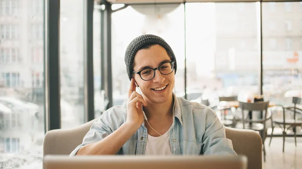Schöner Geschäftsmann in Freizeitkleidung und Brille benutzt einen Laptop im Café — Stockfoto