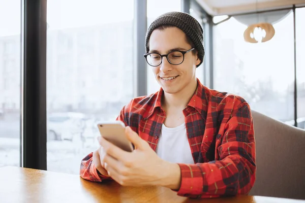 Çekici bir genç adam veya serbest meslek sahibi kafede kahve molası sırasında oturuyor