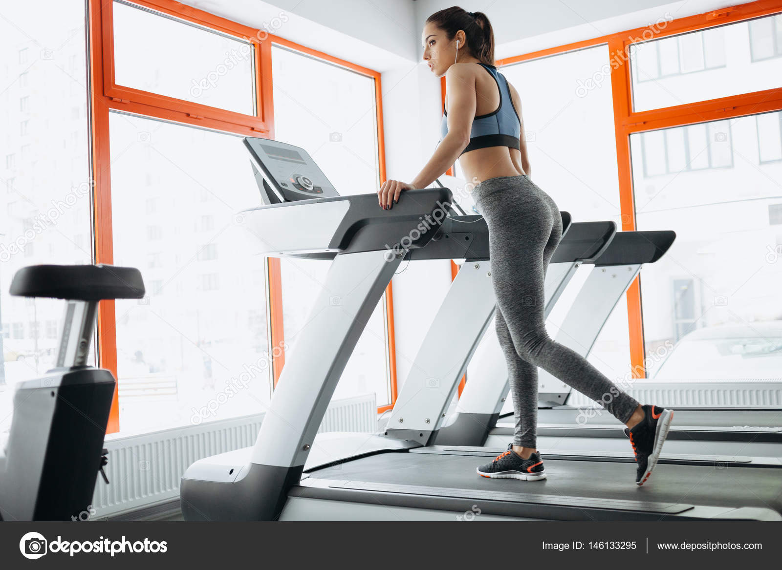 Young fit pretty woman doing exercises on the treadmill Stock