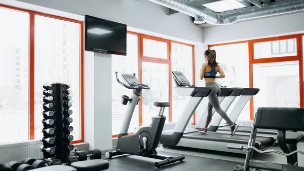 Young fit pretty woman doing exercises on the treadmill — Stock Photo, Image