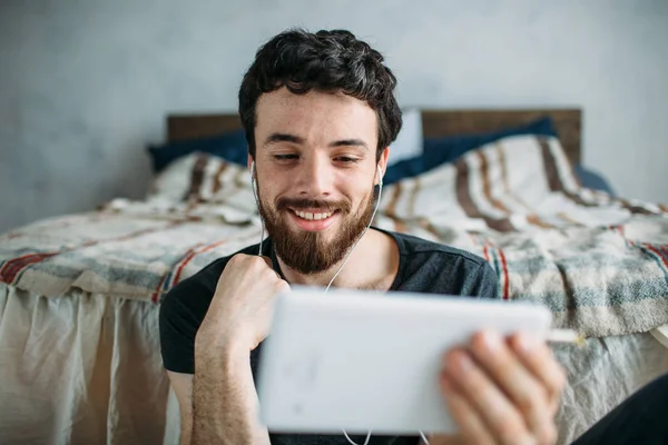 Portret van een tevreden jonge man ontspannen en kijken naar een Tv-show op een tablet-pc — Stockfoto