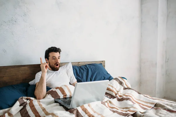 Bebaarde man liggen in ochtend bed met laptop — Stockfoto