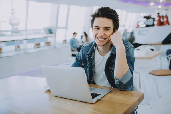 Genç adam bir macbook ya da kafede dizüstü bilgisayar üzerinde çalışan