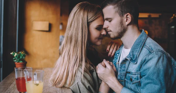 Retrato de una hermosa pareja joven enamorada en una cafetería . — Foto de Stock