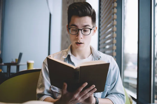 Gutaussehender Geschäftsmann liest im Café ein Buch — Stockfoto